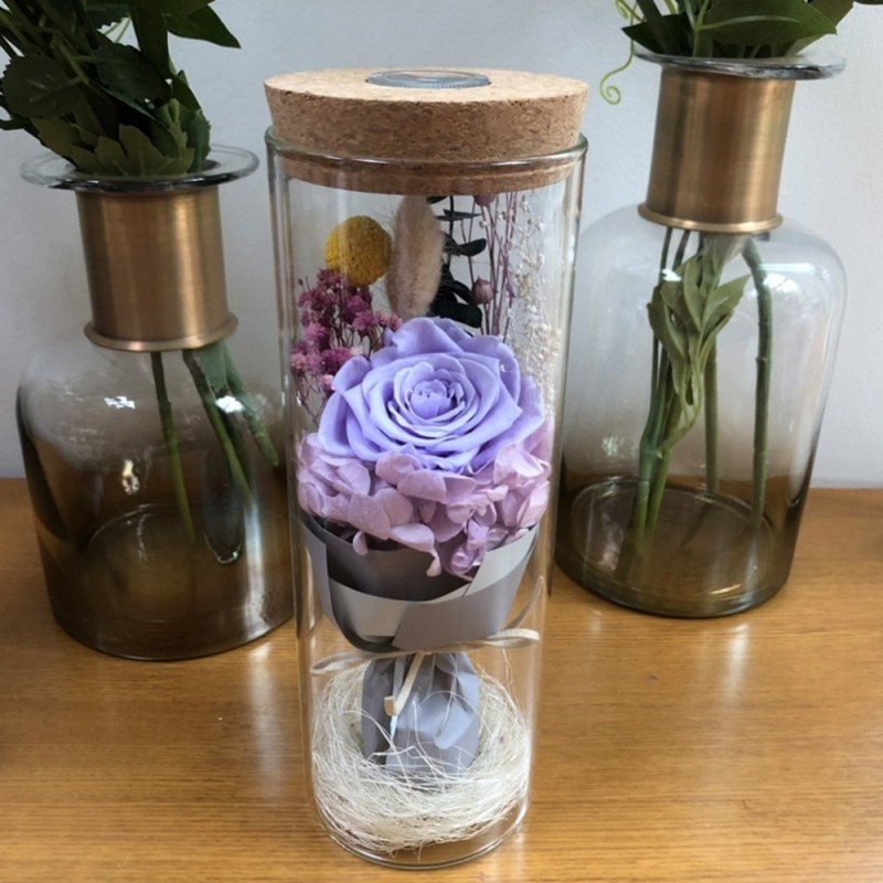 Bukett av oändlighet rosor i en glasvas med LED-ljus